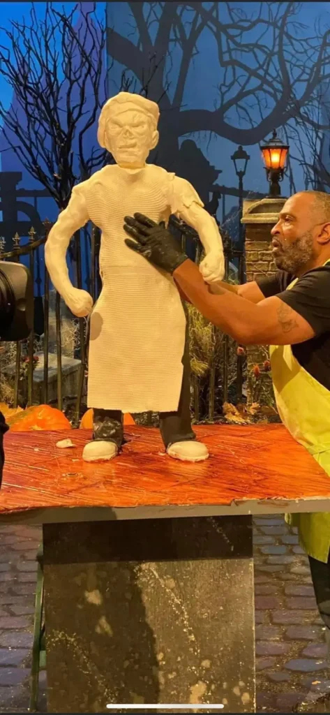 Reggie shaping a sculpted butcher figure on the Halloween Wars set
