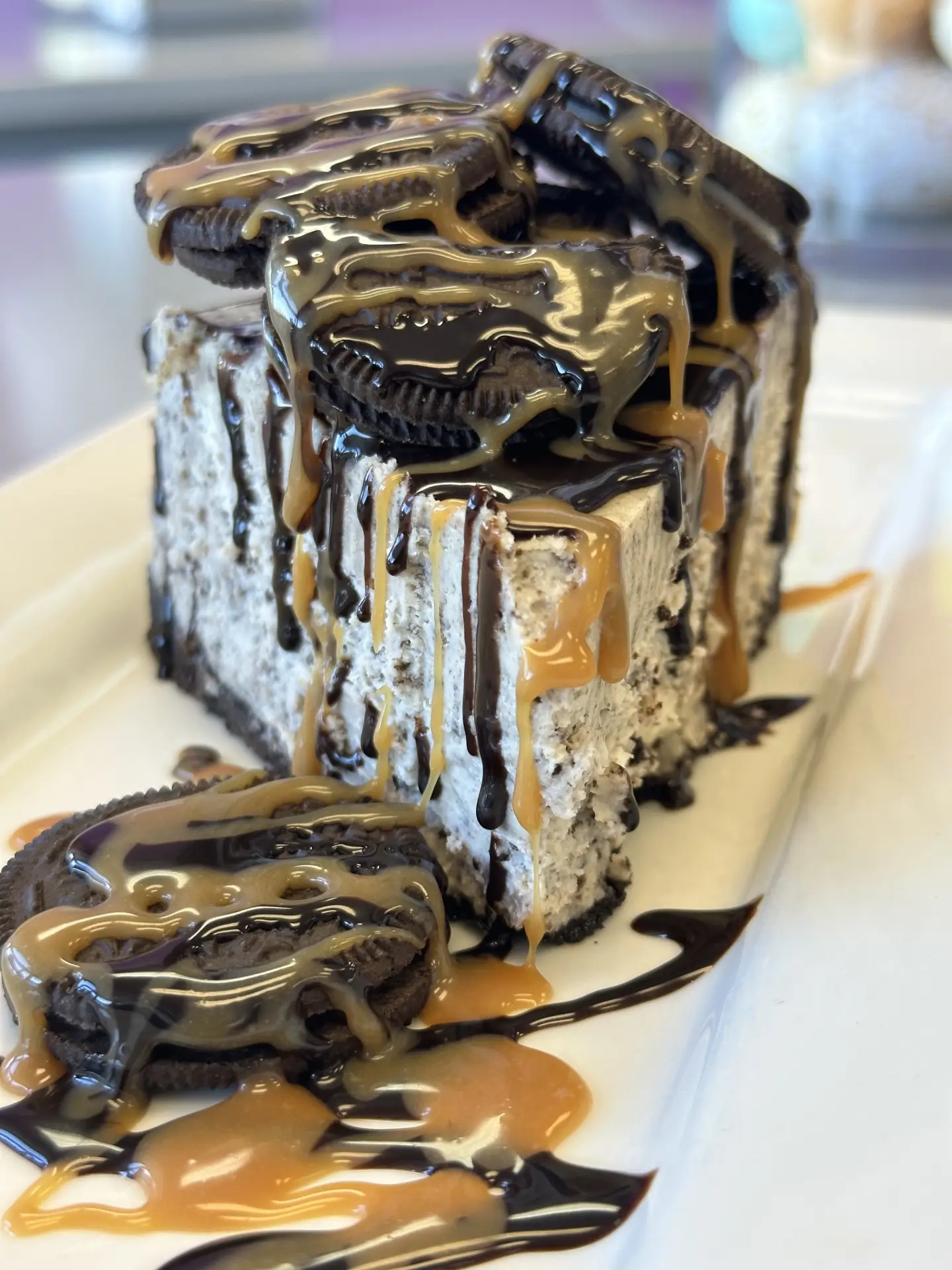 Cookies and cream cheesecake slice with chocolate and caramel drizzle